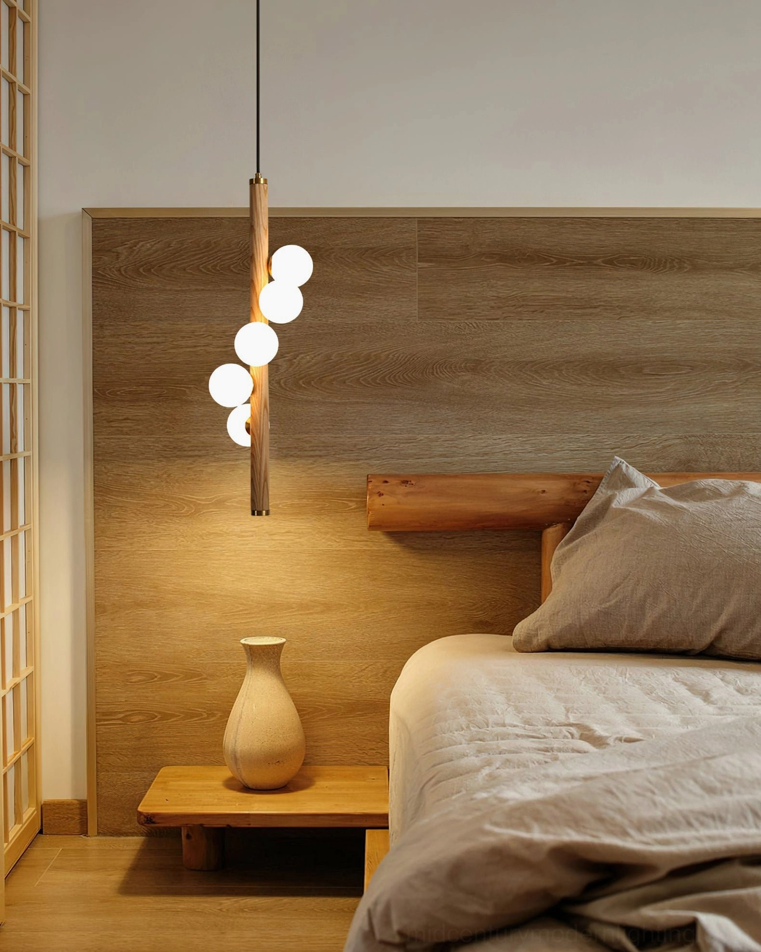Miller pendant light in modern master bedroom, three illuminated spherical bulbs coordinating with warm wood bedroom furniture