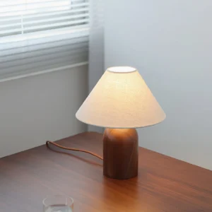 Milo Linen Table Lamp on bedroom desk with soft ambient lighting and window blinds in background