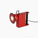 Minibox magnetic spotlight table lamp in bright red, three-quarter view, studio shot with geometric boxy design and glowing spotlight head