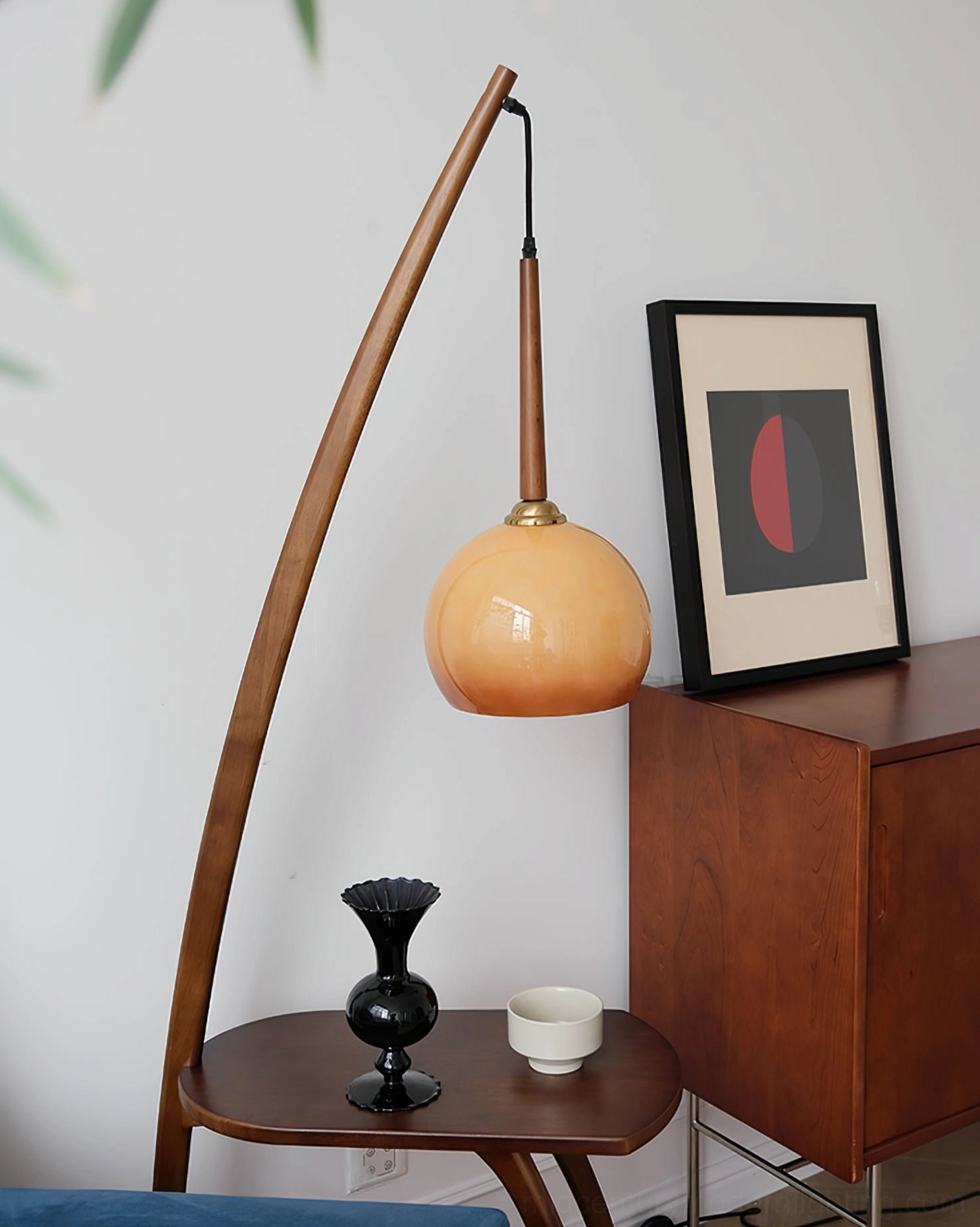 Mid-century modern arc floor lamp with side table in minimalist living room with wall art