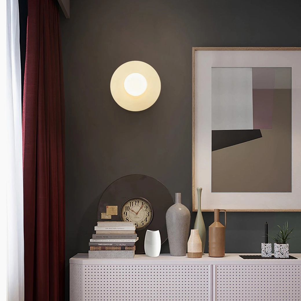 Single frosted glass sphere wall sconce mounted on contemporary gray entryway wall