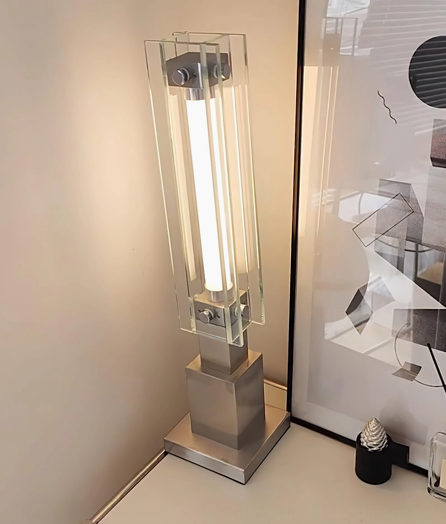 Sleek glass table lamp with chrome base in minimalist modern interior design setting