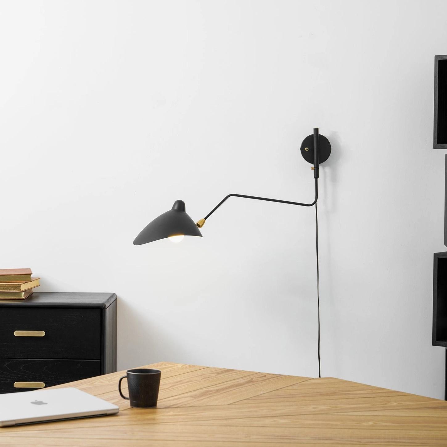 Modern minimalist interior featuring matte black spider wall sconce as accent lighting