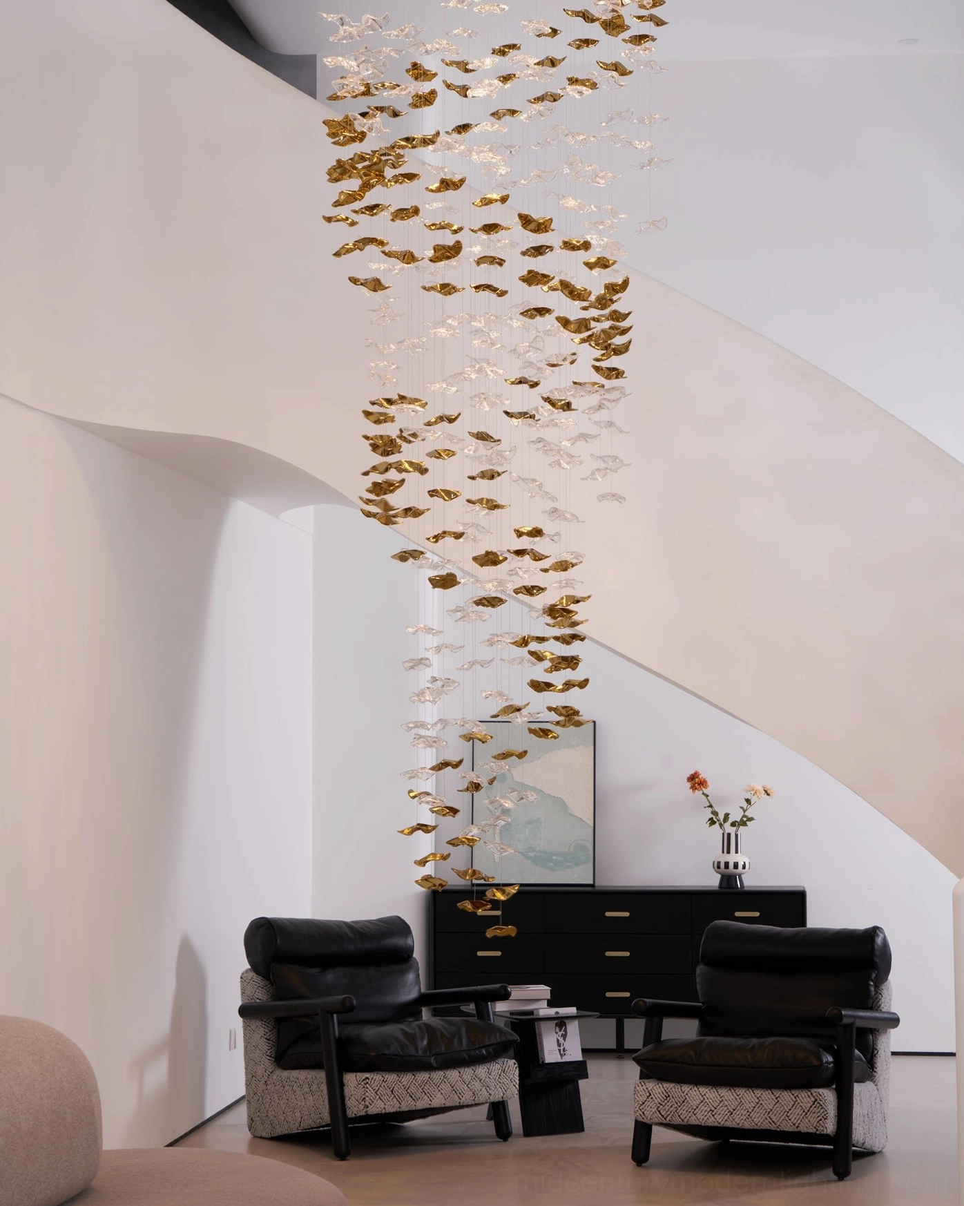 Modern minimalist living space with vertical fluid glass chandelier clear to golden gradient pendants