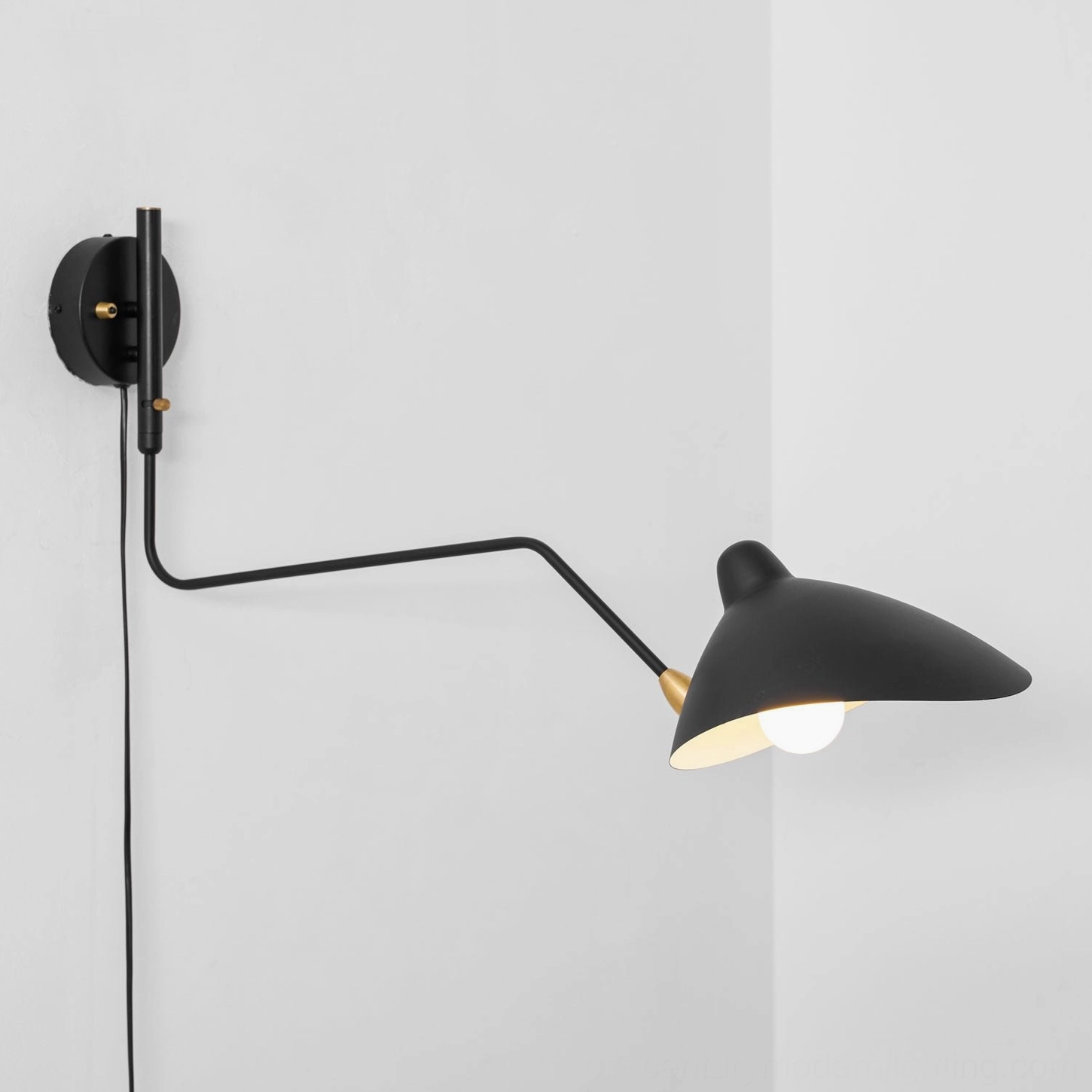 Minimalist plug-in wall sconce featuring articulated spider arm configuration