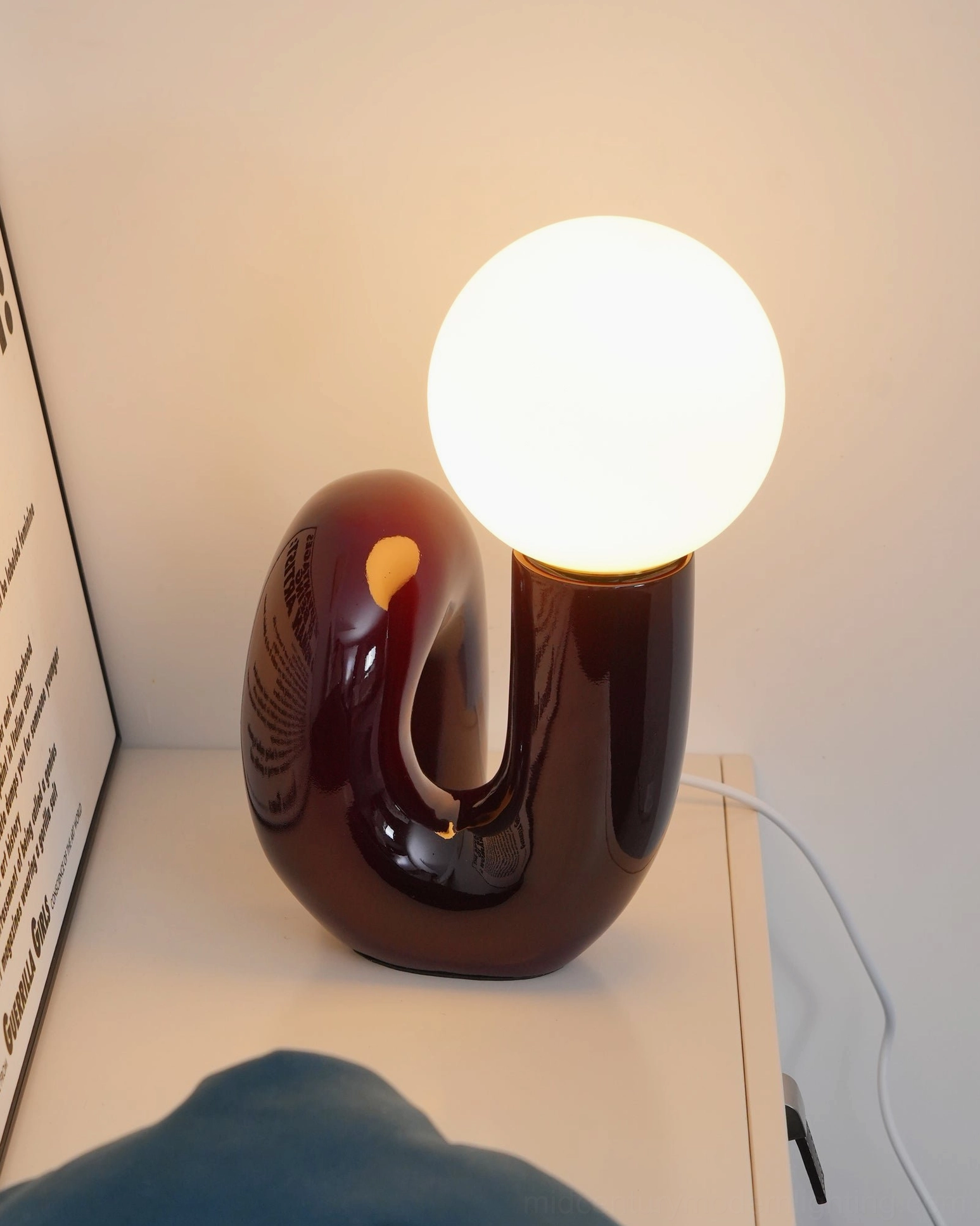 Minimalist spiral table lamp styling on home furniture console with books and design accessories