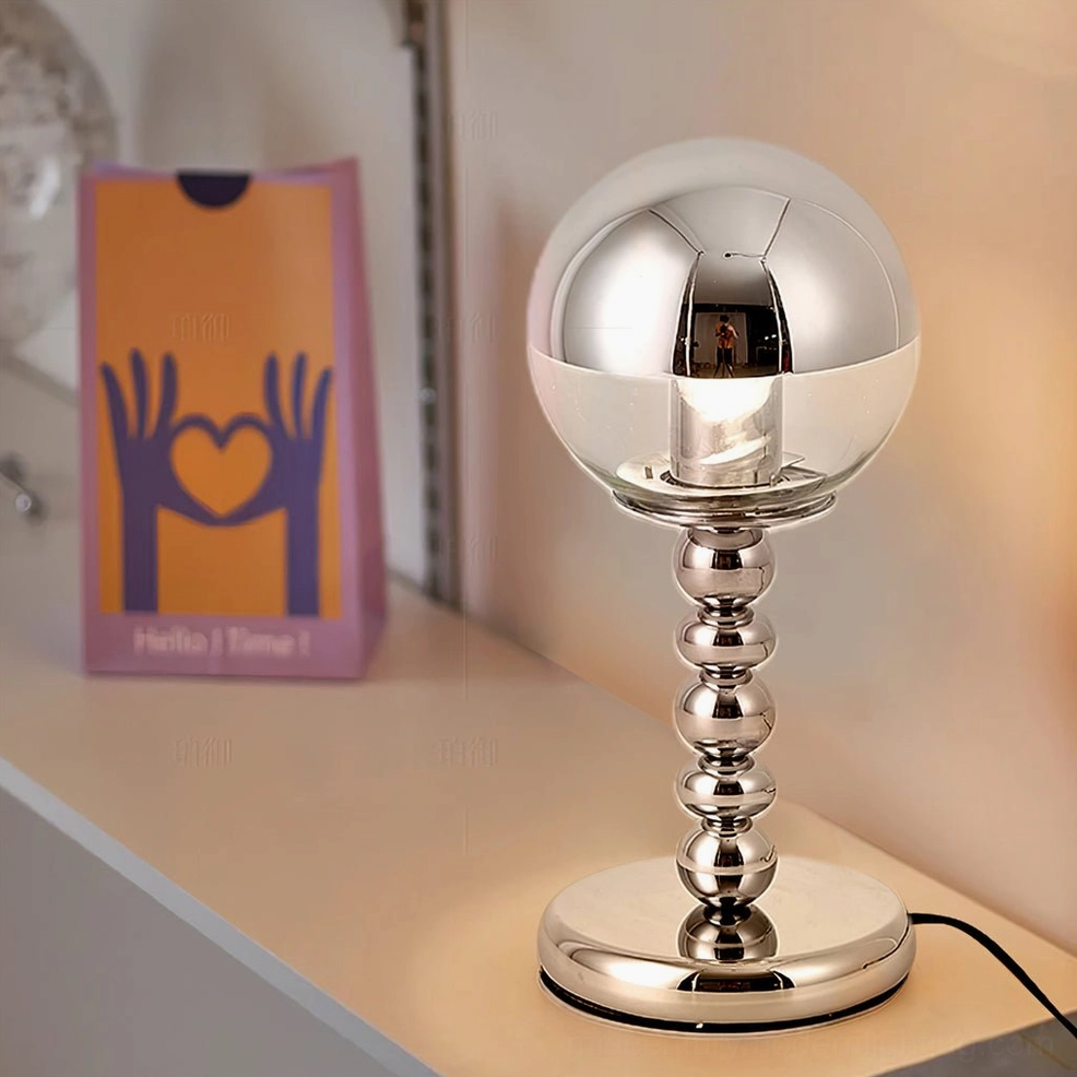 Glowing chrome Mirrorball lamp on bedroom vanity creating ambient light with geometric sphere design
