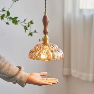 Warm amber fluted glass pendant lamp with brass hardware and wooden grip, hands-on styling with cozy indoor lighting