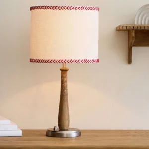 Close-up detail of Mitchell table lamp base and wood grain pole on natural wood tabletop surface