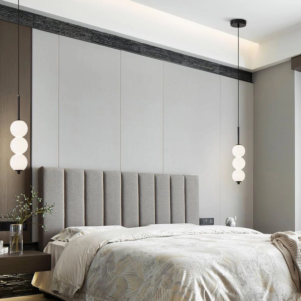 Two Orbet pendant lamps with different orb counts installed above tufted bed in master bedroom