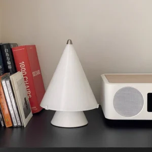 Miza cordless modern table lamp three-quarter view on dark desk with books and speaker