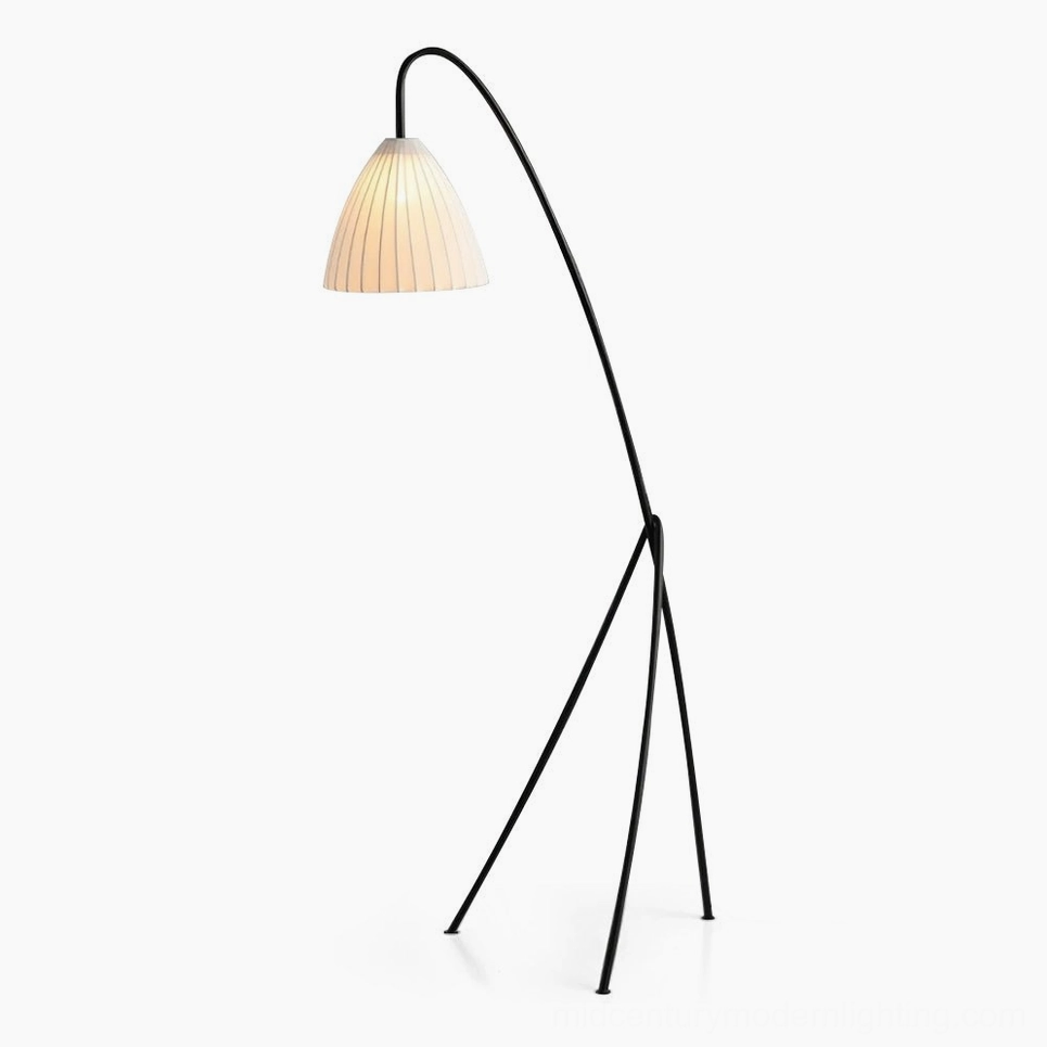 Modern arc tripod floor lamp with pleated beige shade against white studio background, side view showing geometric metal frame and curved arm design