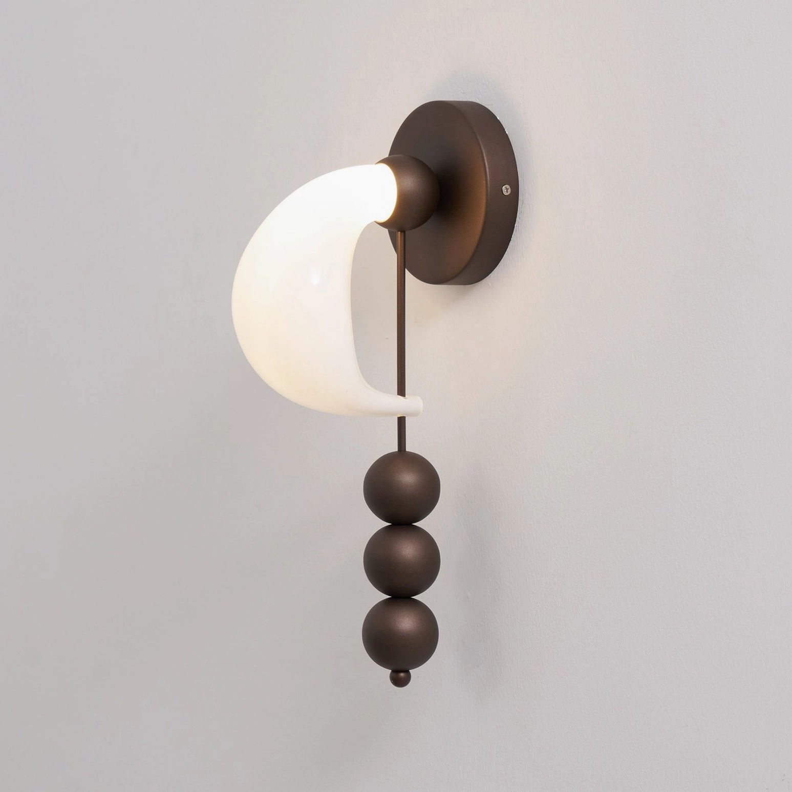 Modern bent glass wall sconce with three spheres and hand-formed shade, energy-efficient integrated LED illumination