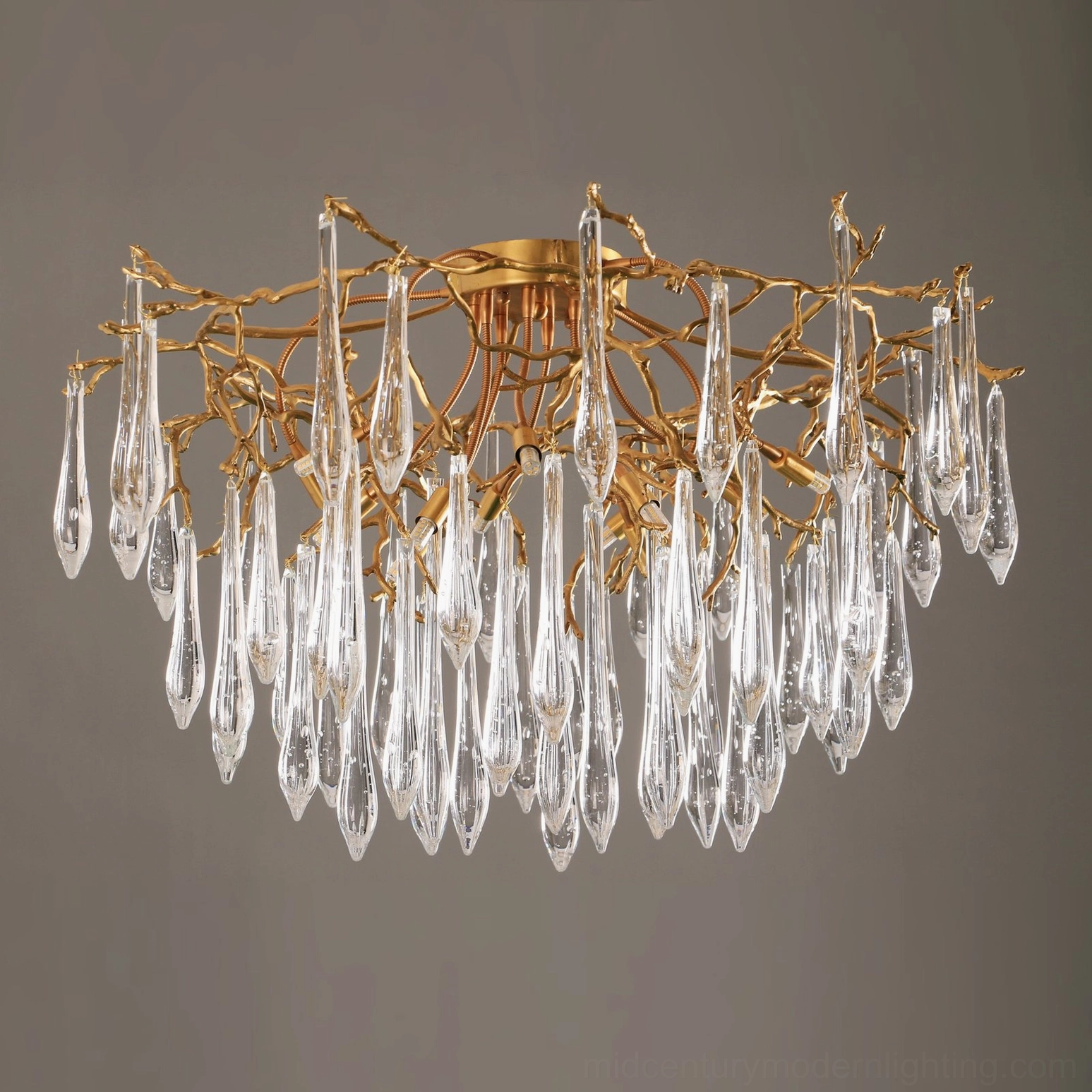 Modern brass ceiling light pendant with clear glass teardrop elements, sculptural form