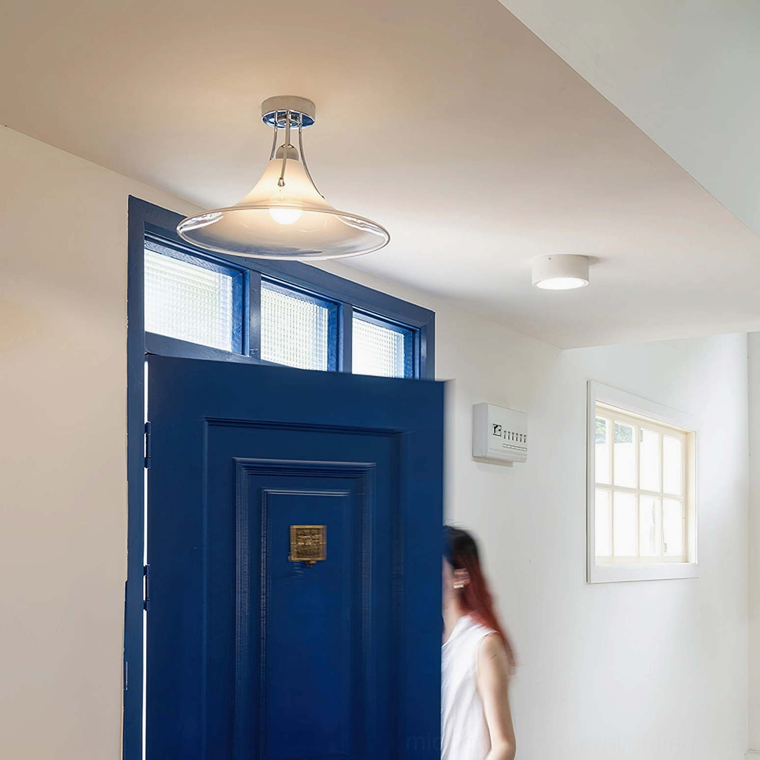 Mid-century modern ceiling lamp in residential hallway showing cozy minimalist home decor style with chrome fixtures
