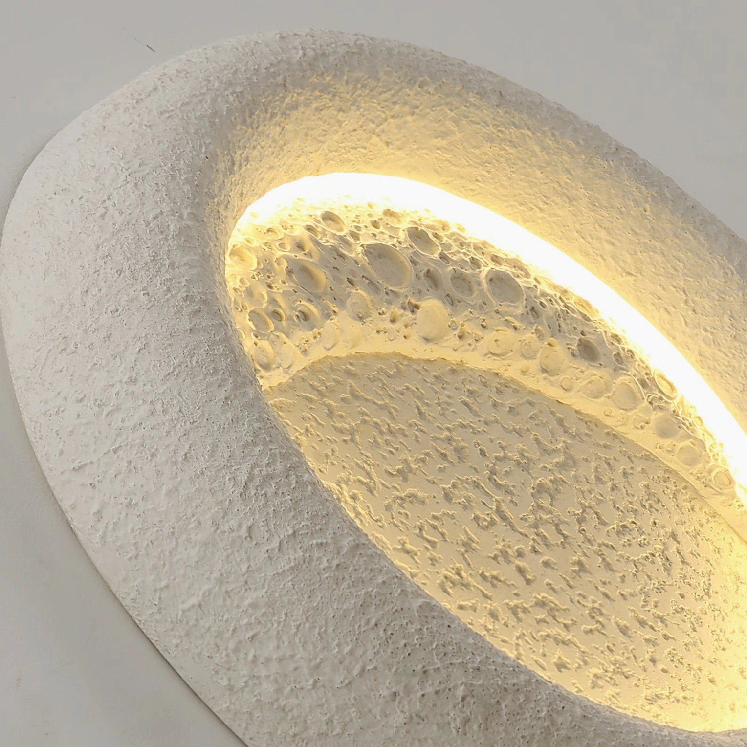 Modern ceiling light fixture side profile showing thick rounded edge and warm glow from LED