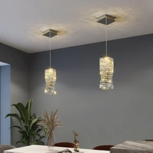 Multiple faceted crystal pendant lights installed in modern dining room with square ceiling mounts and warm ambient lighting