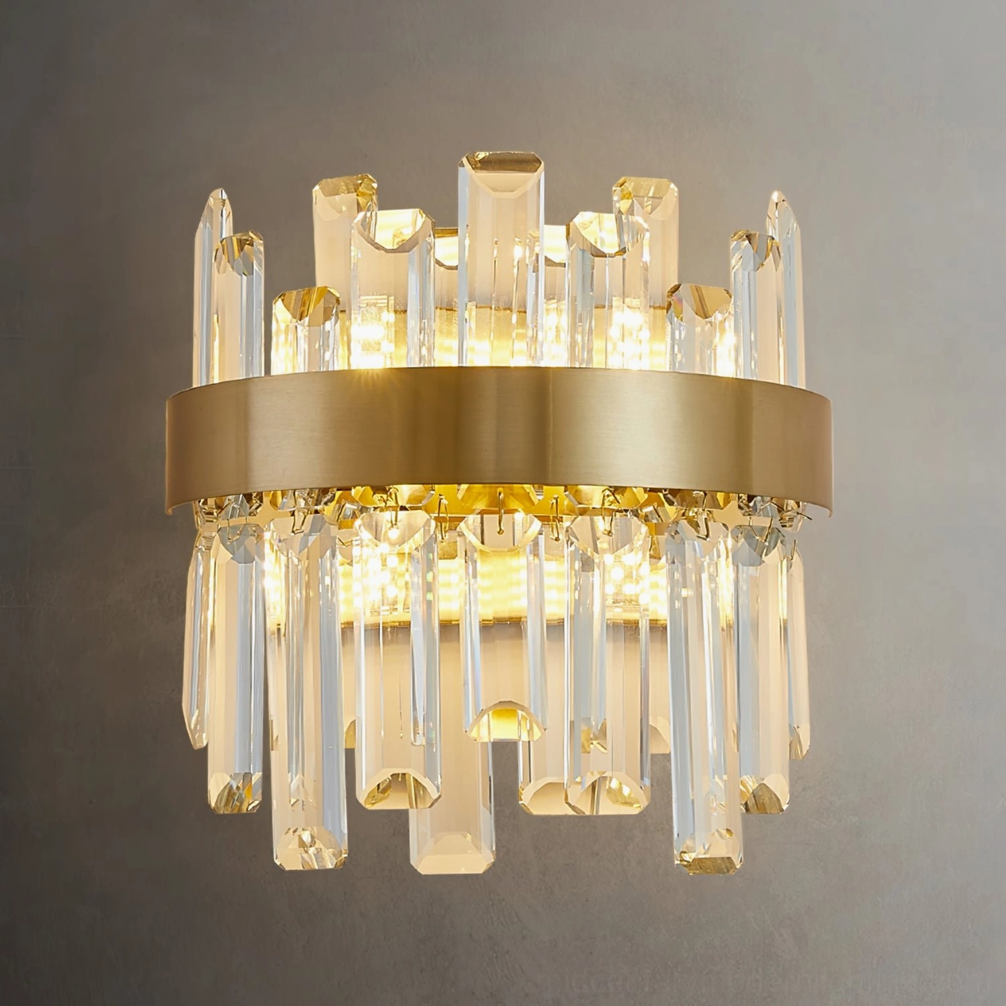 Modern crystal wall sconce displaying warm brass finish and cascading crystal elements in contemporary interior setting