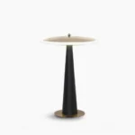 Drums disc table lamp with matte black pole and polished gold base, studio front view