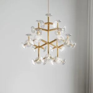 Symmetrical snowflake-style brass chandelier hanging in minimalist white interior design space