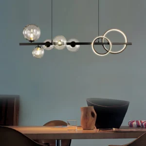 Modern glass bubble pendant light installed in contemporary dining room with teal accent wall, clear glass orbs with warm LED lighting