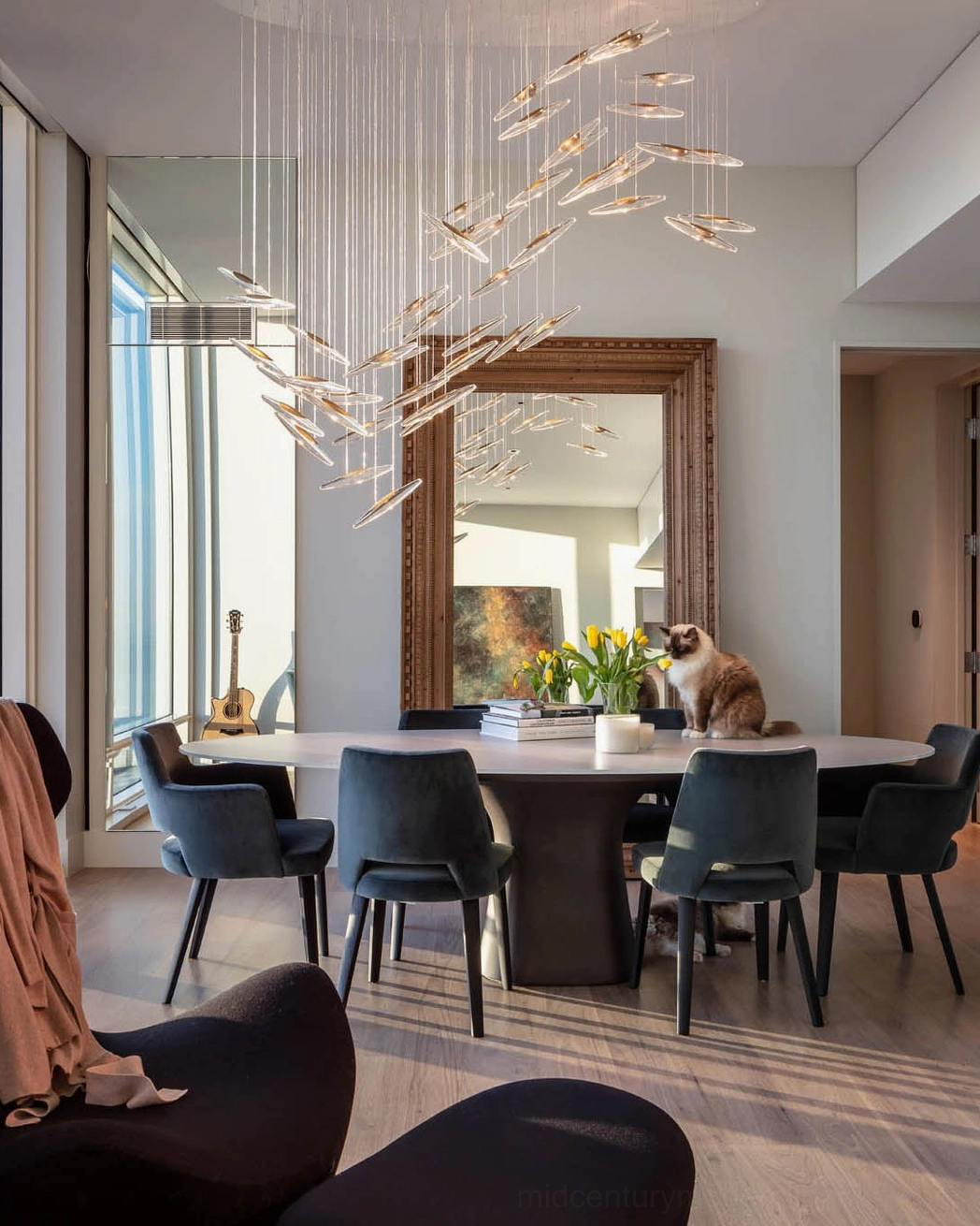 Modern glass chandelier with warm lighting above dining table in cozy contemporary dining space interior