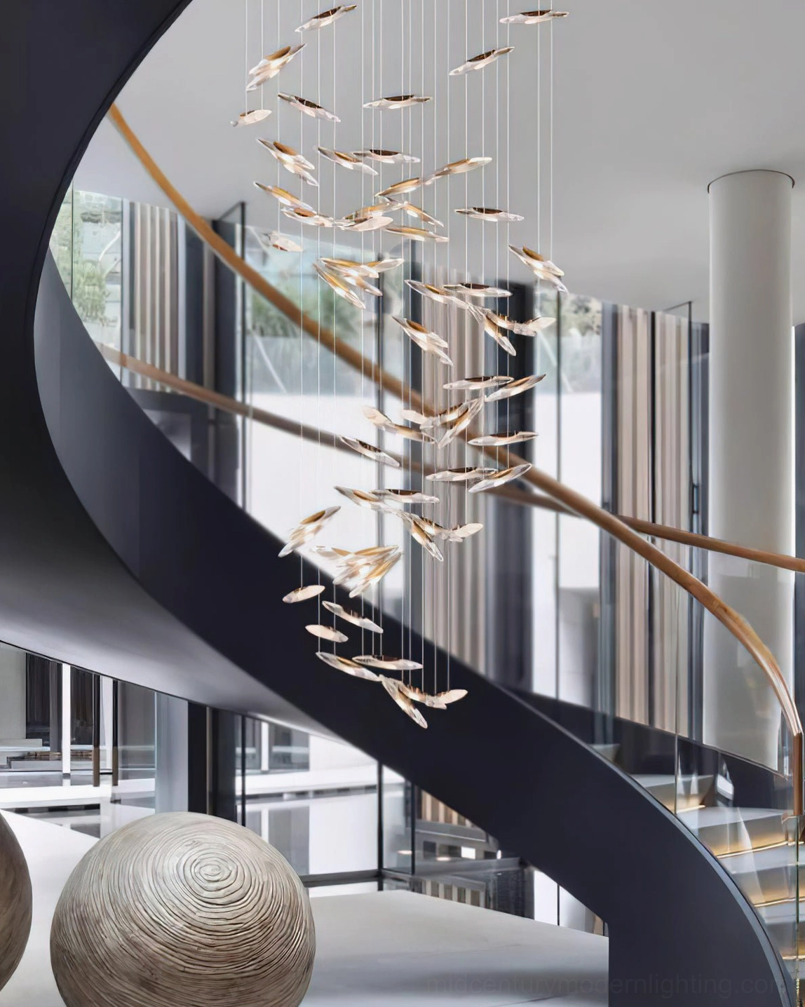 Modern glass chandelier installation above dining furniture showing scale and spatial impact
