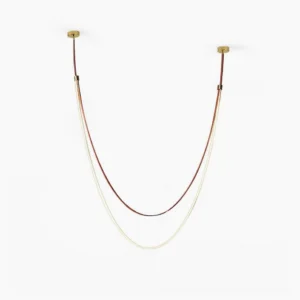Minimalist sculptural leather pendant lamp with dual-tone strap design and gold ceiling fixtures on white background