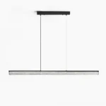 Modern linear LED pendant chandelier with rippled glass diffuser and matte black brass frame, frontal studio view