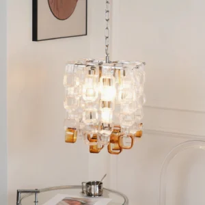 Illuminated Elodie Murano chandelier in modern minimalist living room with side table, close-up pendant detail showing stacked glass construction