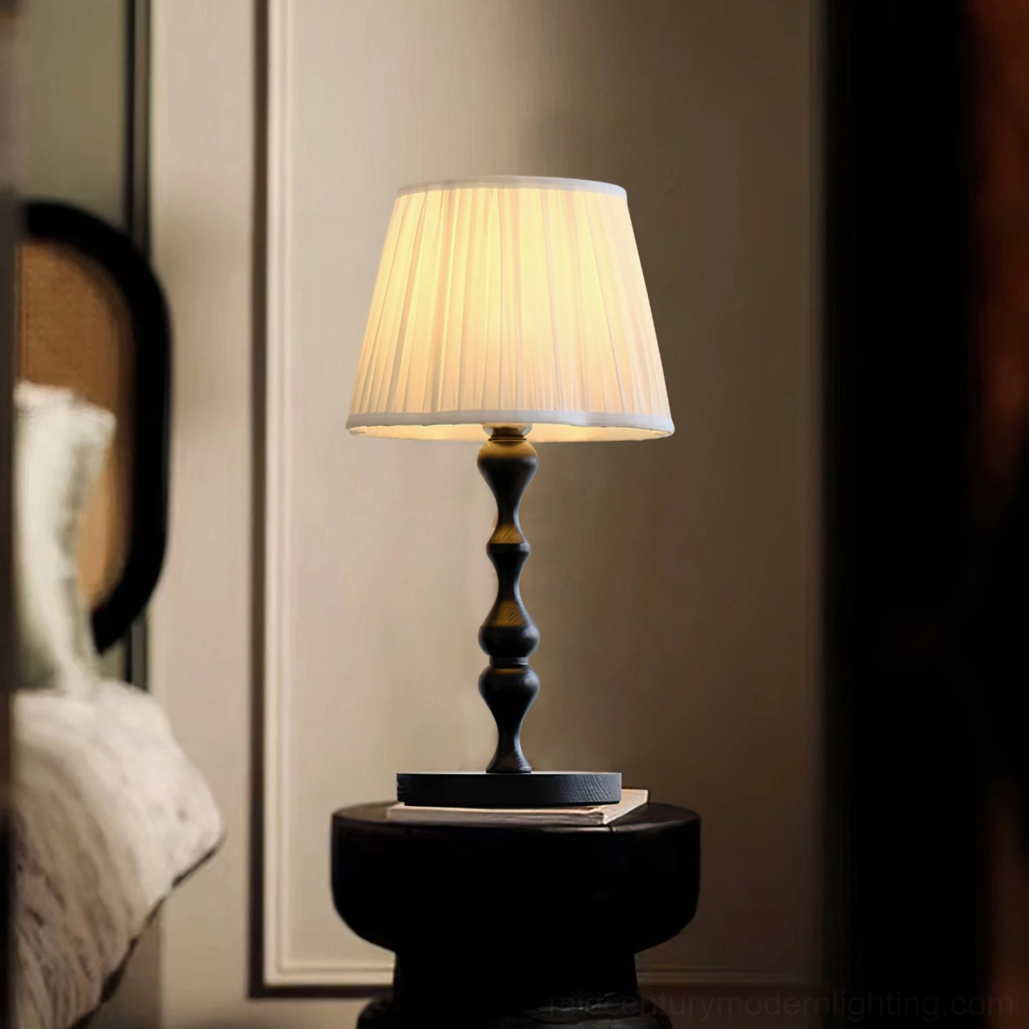 Ambrosia mid-century table lamp illuminated in intimate corner space with wall mirror, stacked books base styling