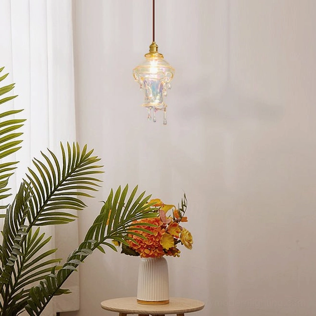 Contemporary drip resin pendant lamp illuminated in living room setting with palm plant and floral arrangement