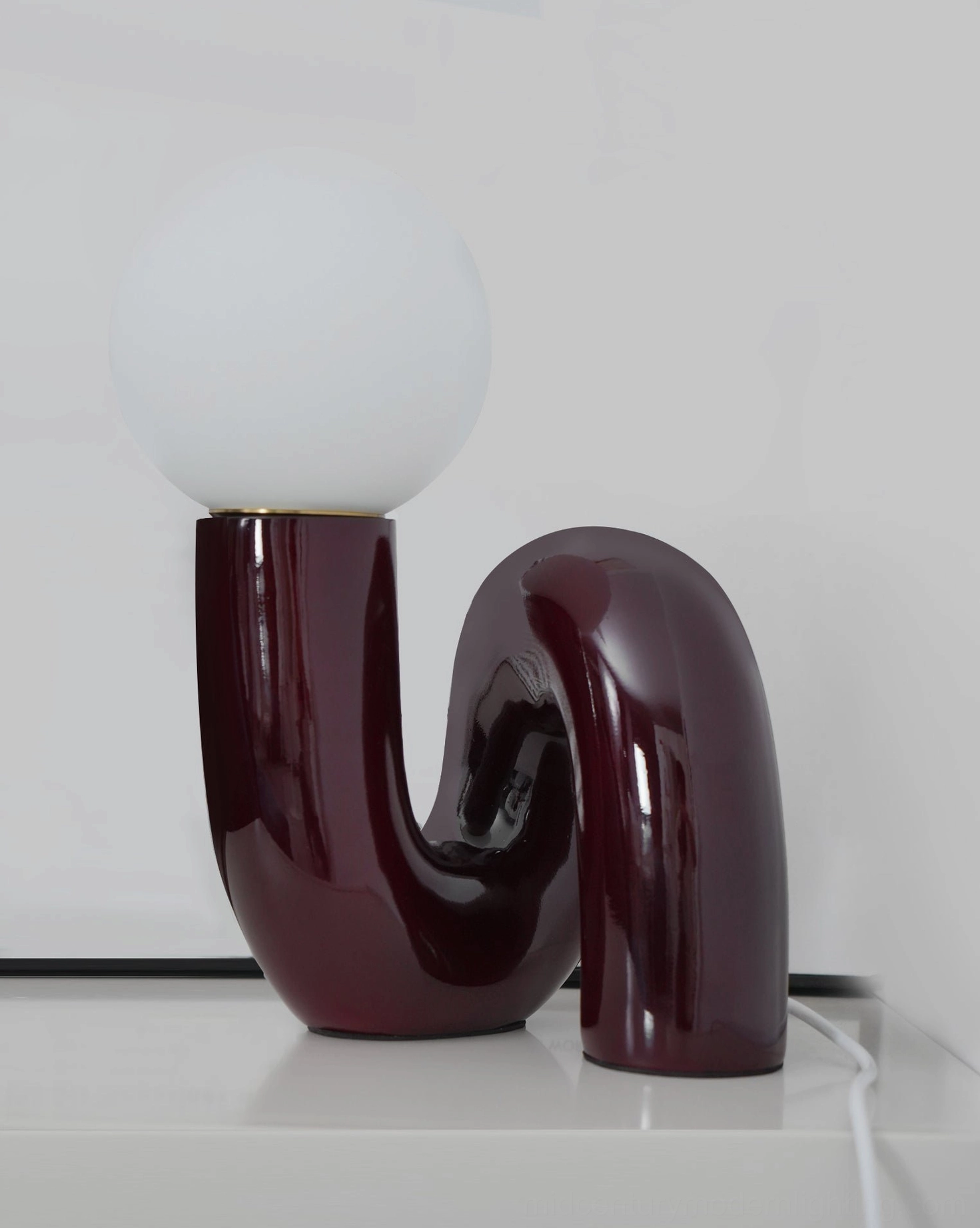 Modern sculptural table lamp with curved fluid resin and glass form, tabletop ready design