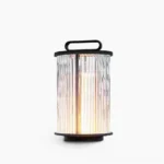 Modern solar glass lantern table lamp with ribbed glass shade and black stainless steel frame, front view studio shot