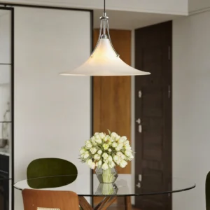 Modern swing arm pendant light installed above dining table in contemporary interior, eye-level view showing frosted glass diffusion and chrome hardware