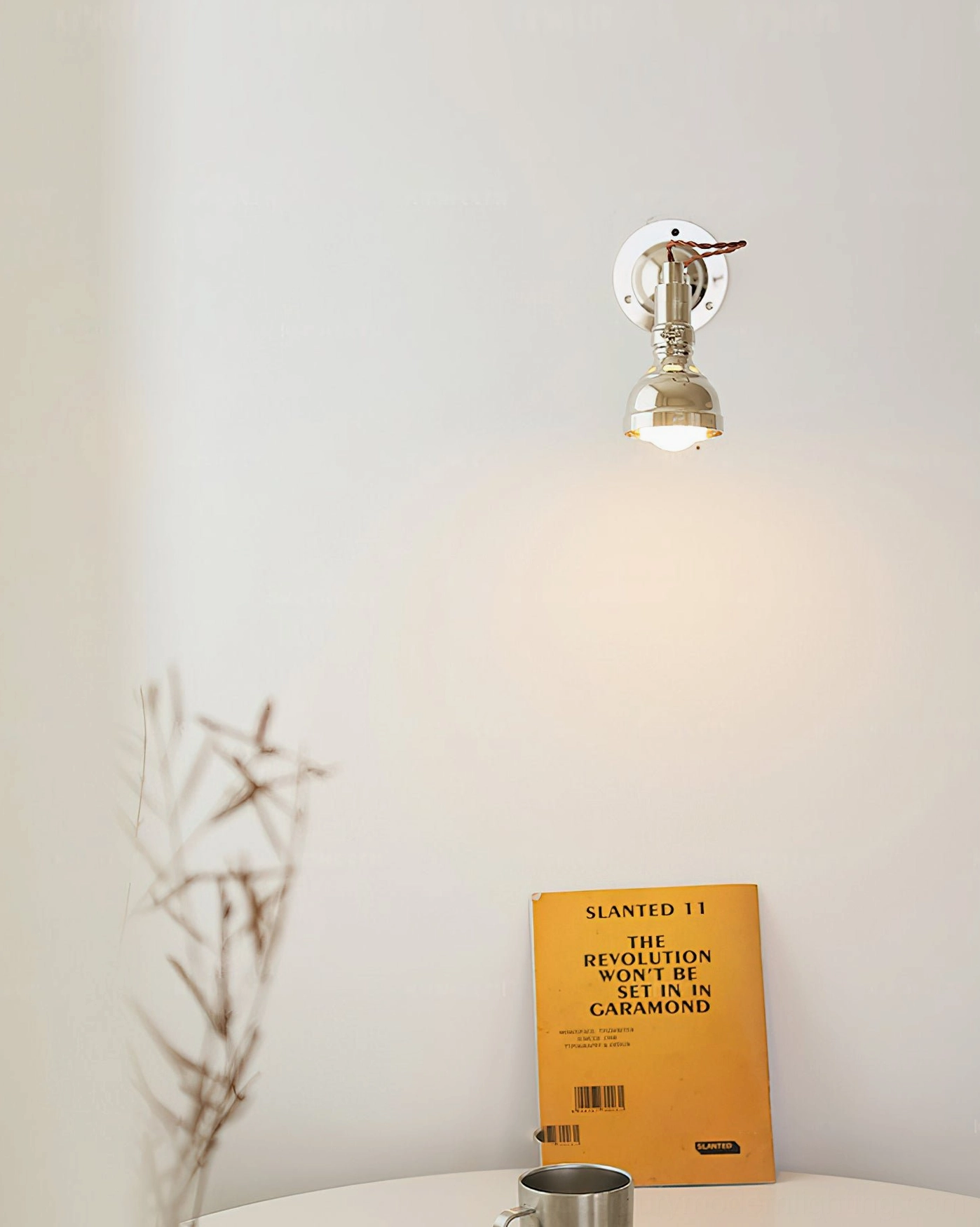 Minimalist swing arm wall sconce top-down frontal view, polished chrome industrial aesthetic