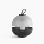 Modern dual-tone table lamp with frosted glass dome and perforated black metal base, studio front view