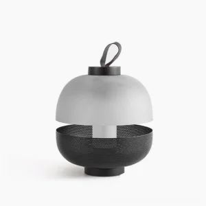 Modern dual-tone table lamp with frosted glass dome and perforated black metal base, studio front view