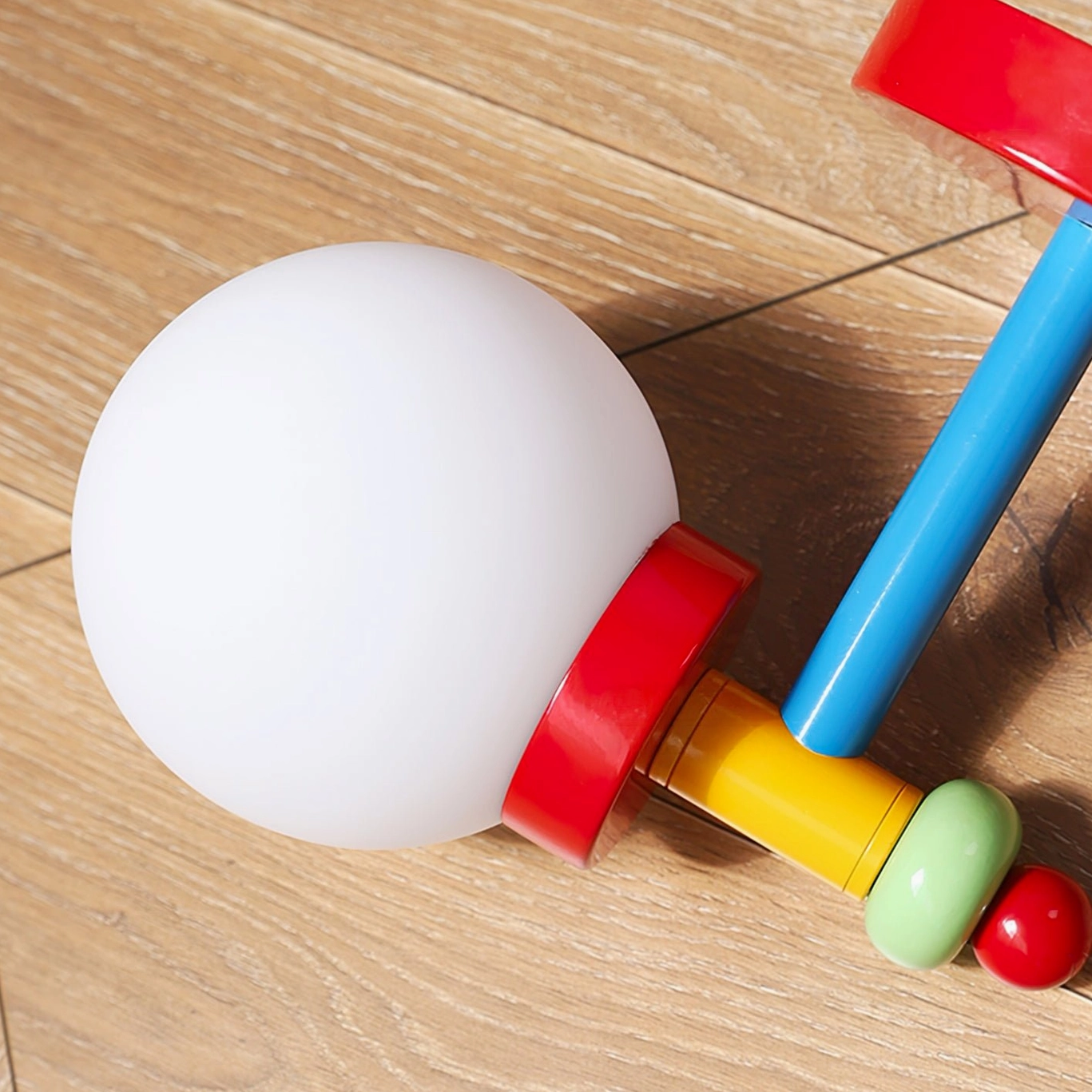 Mid-century modern wall lamp overhead view showing color block structure on wooden surface