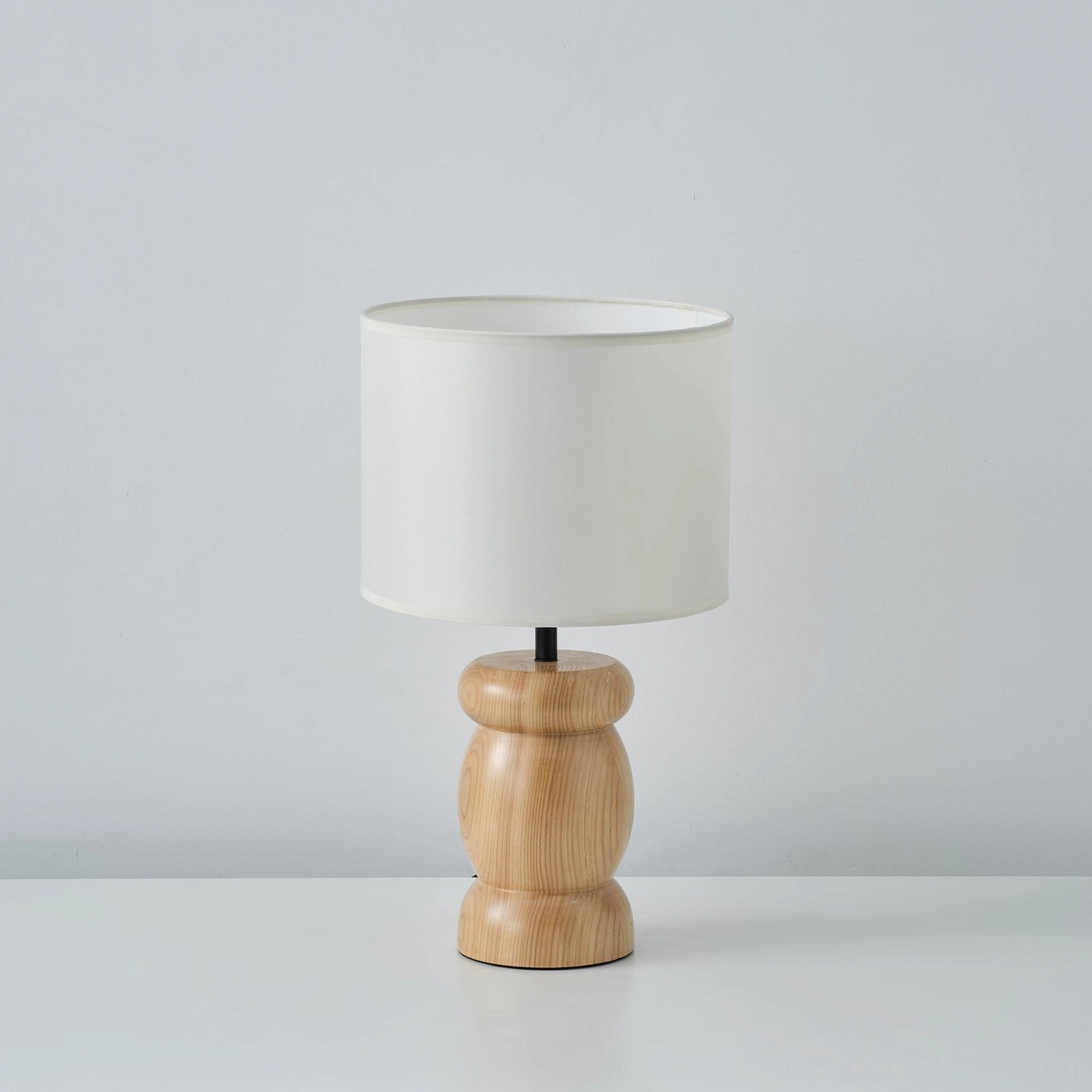 Modern wood table lamp, minimalist design with off-white shade and natural wood finish, front view on neutral background