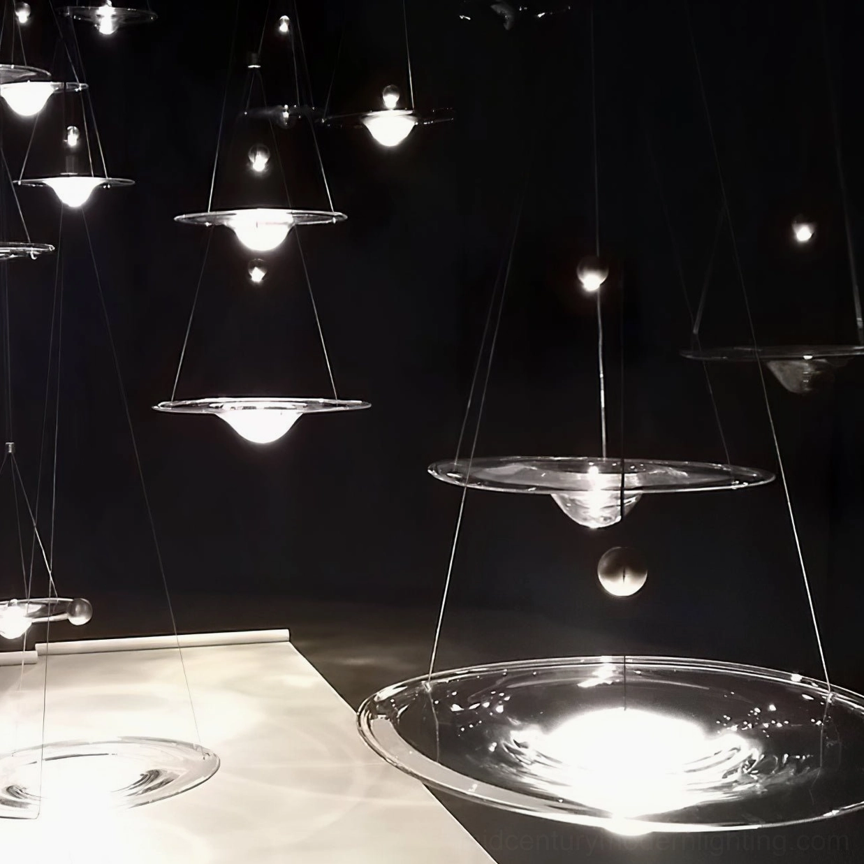 Momento glass pendant light fixture with clear sphere and metal suspension showing industrial elements