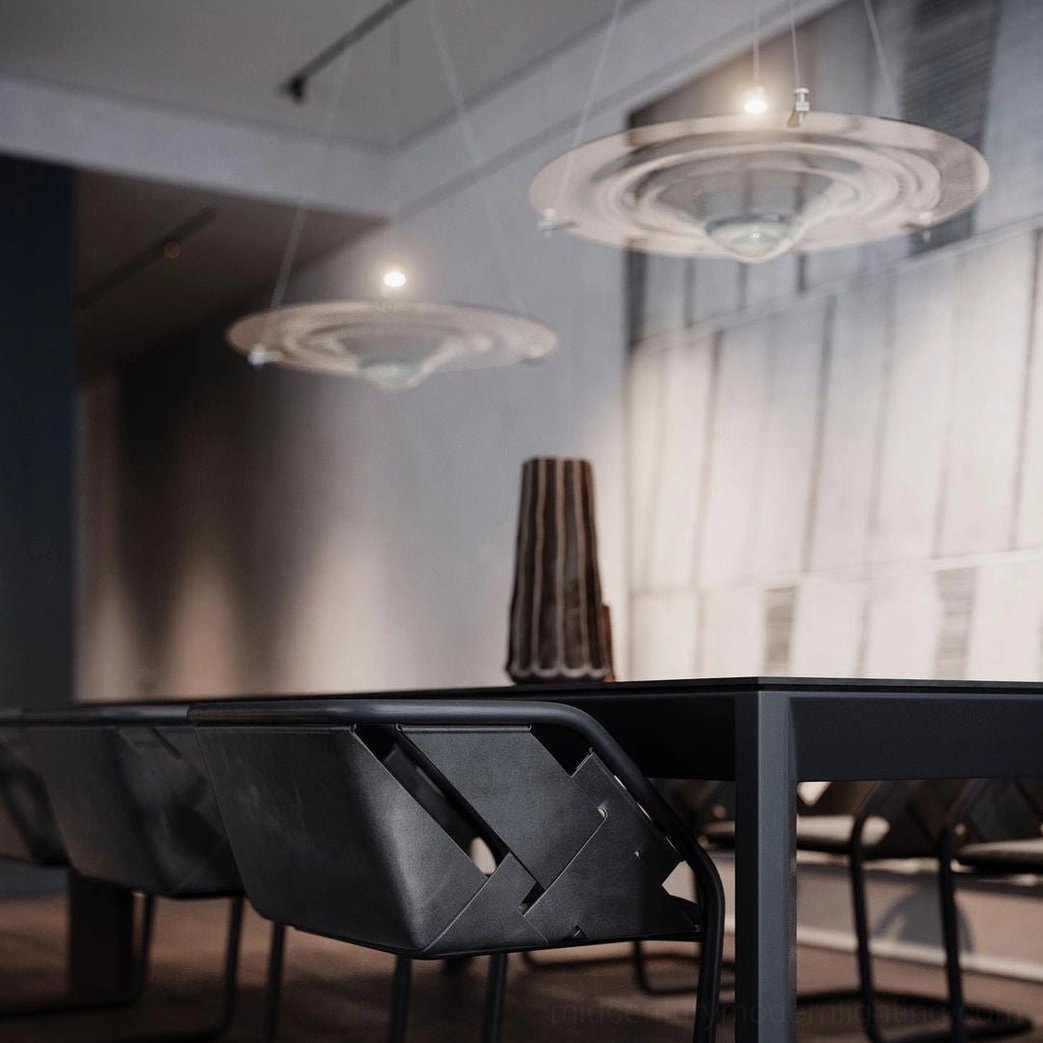 Two Momento saucer pendant lamps suspended above modern black dining furniture with integrated LED warm lighting