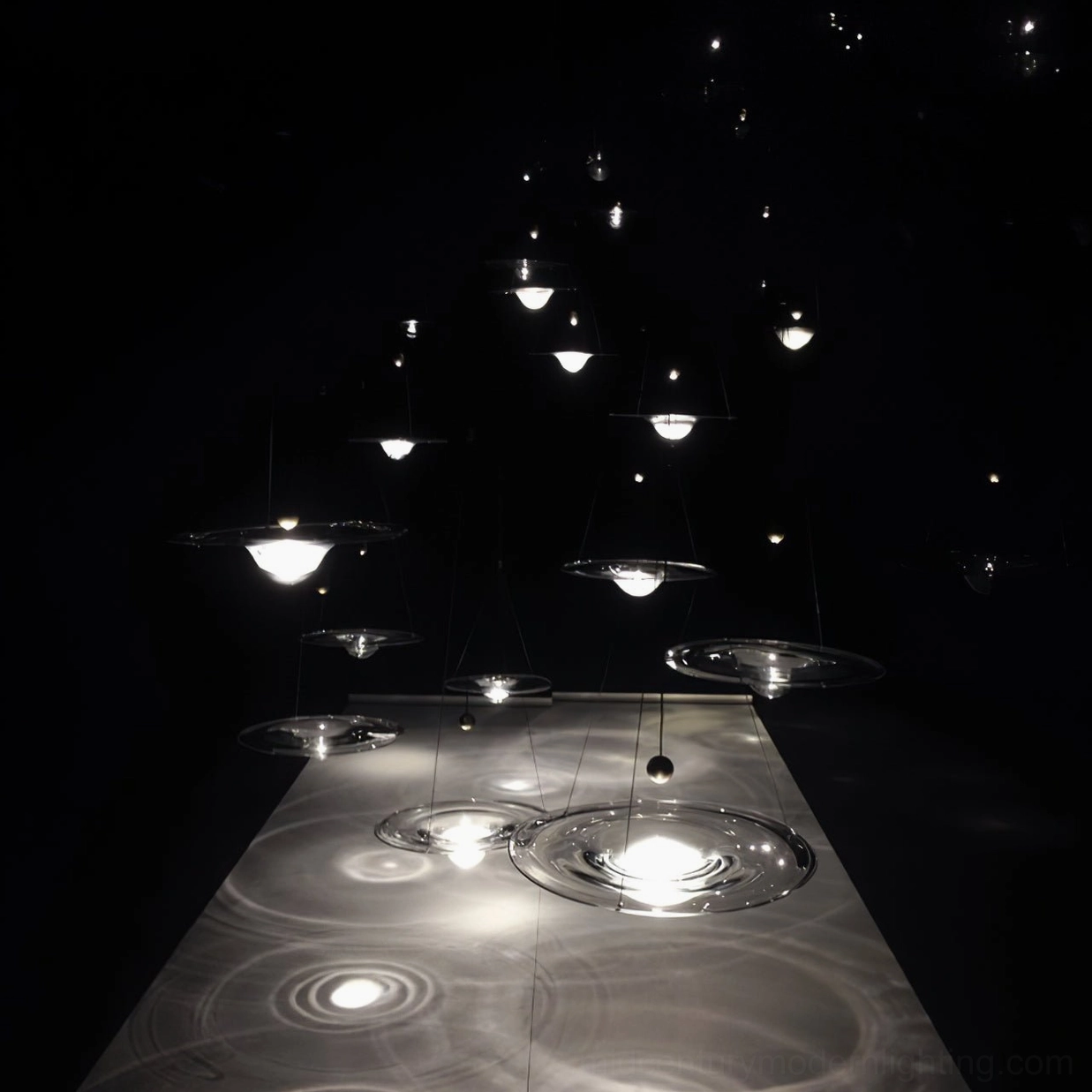 Overhead view of Momento pendant lights creating ripple light patterns and ambient glow on dining table