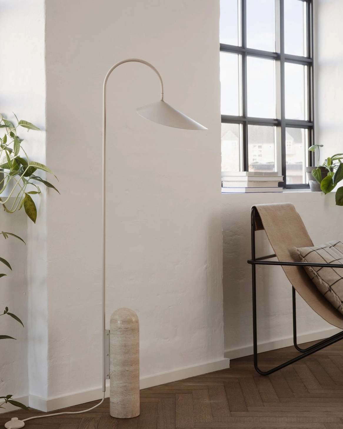 Mono floor lamp beige finish in bright minimalist living room with grid window and lounge chair