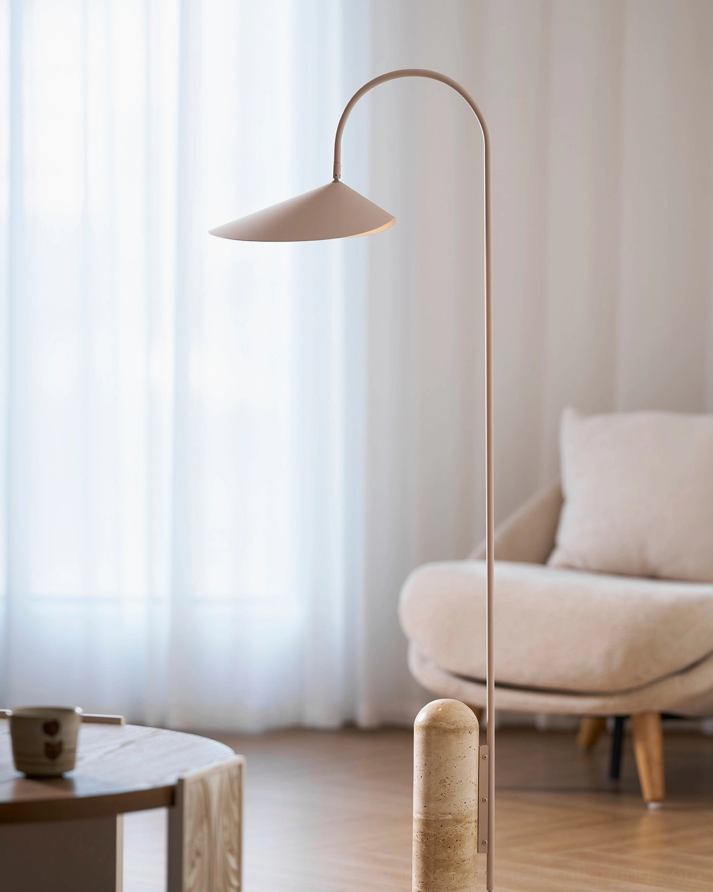 Mono floor lamp with beige cavestone base in styled minimalist interior setting with neutral decor
