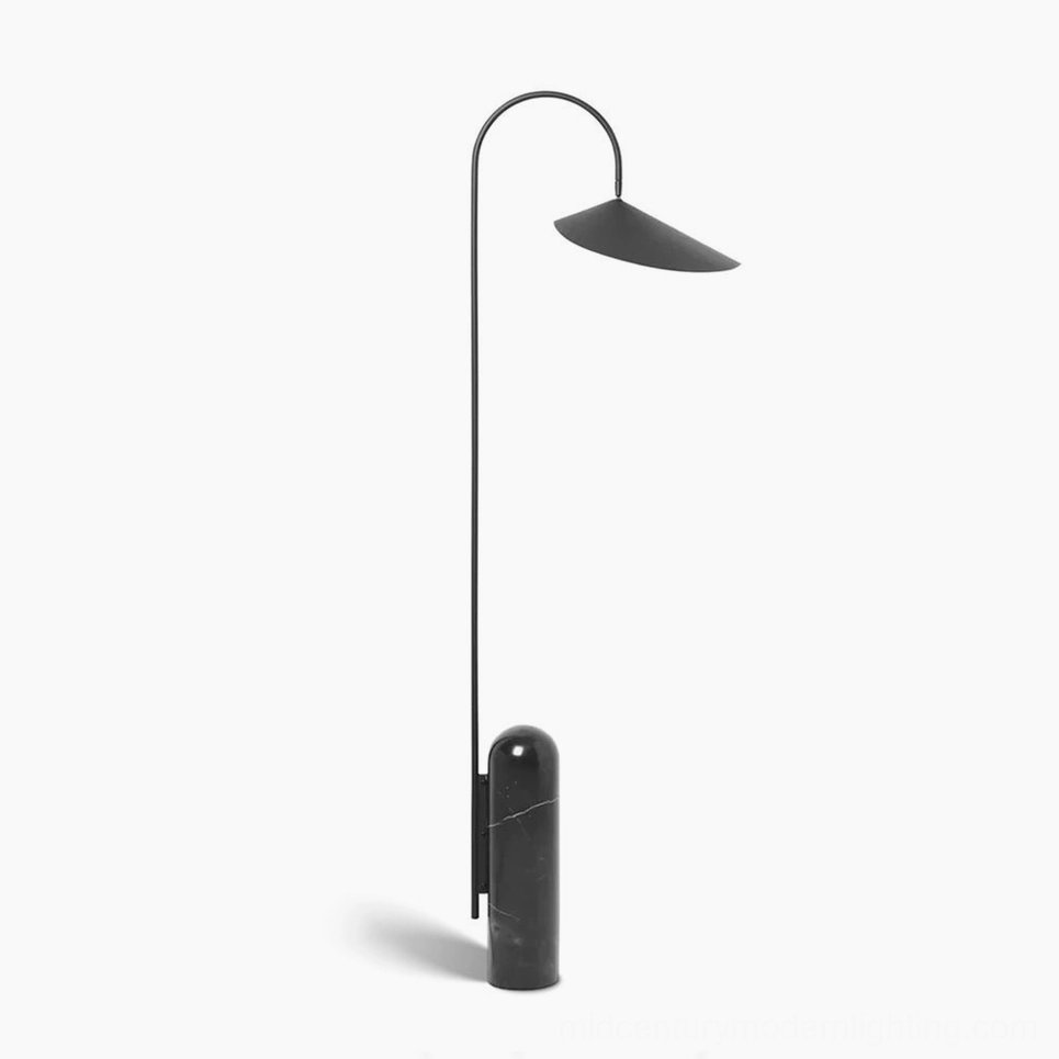 Mono floor lamp with black matte metal curved arc and black cavestone base on white background, minimalist sculptural design