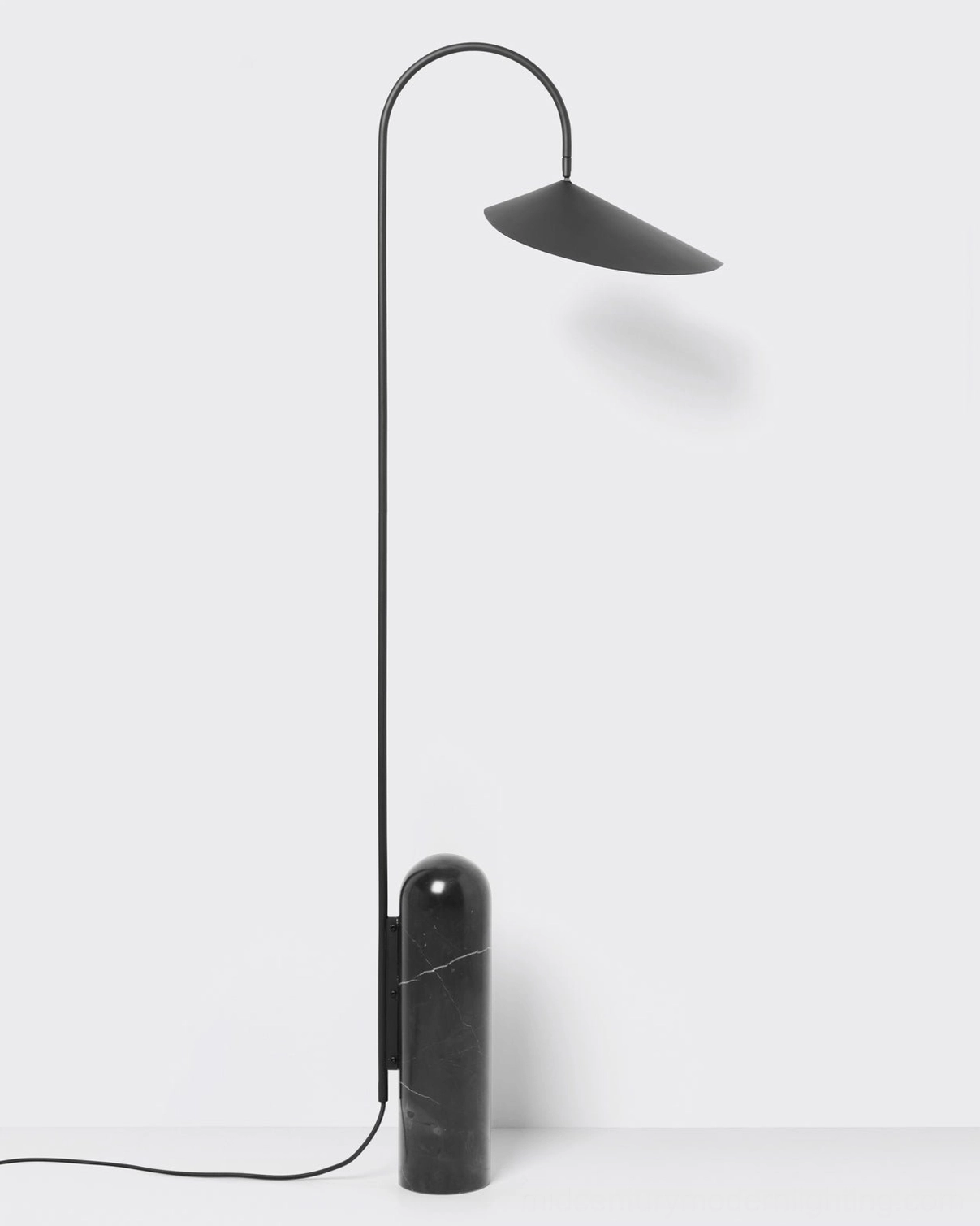 Mono floor lamp studio shot showing sculptural metal arc arm and conical shade on white background