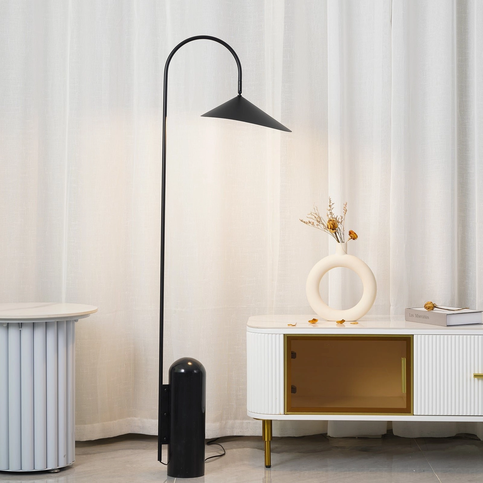 Mono floor lamp positioned for task lighting beside reading chair and side table