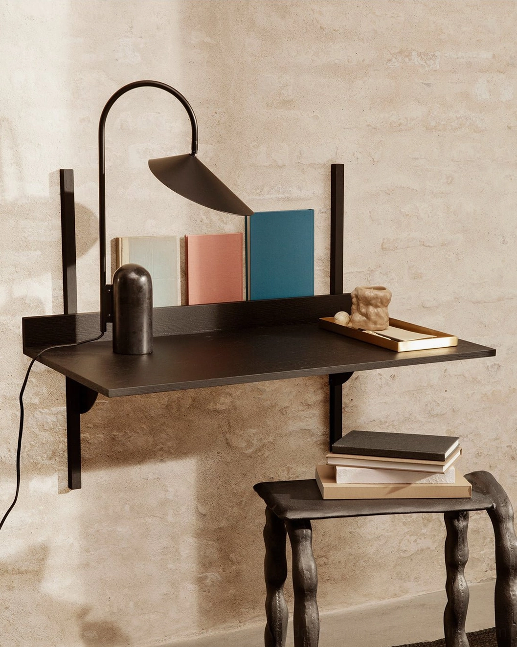 Black table lamp with conical shade sculptural arc stem and cavestone marble base