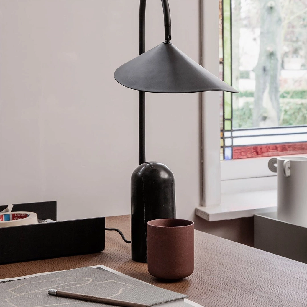 Black Mono lamp with sculptural arch design and marble base in contemporary home setting